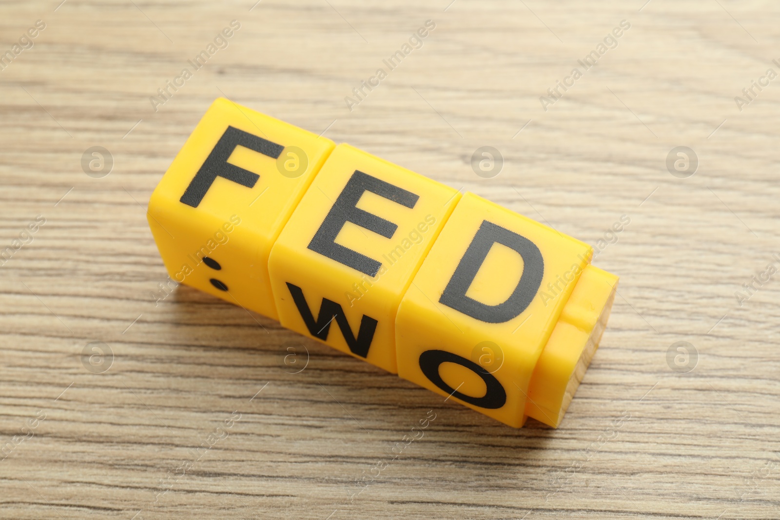 Photo of Cubes with letters Fed (Federal Reserve System) on wooden table, closeup