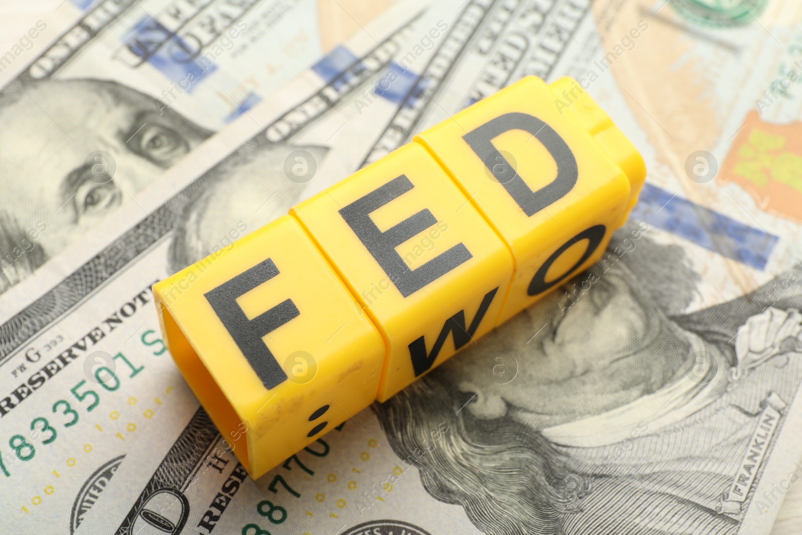 Photo of Cubes with letters Fed (Federal Reserve System) and dollar banknotes, closeup