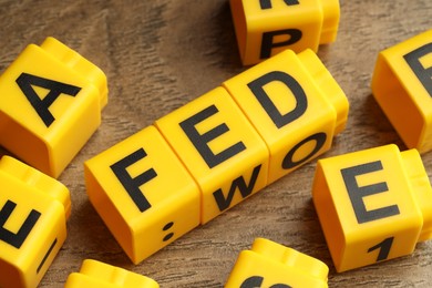 Photo of Cubes with letters Fed (Federal Reserve System) on wooden table, closeup