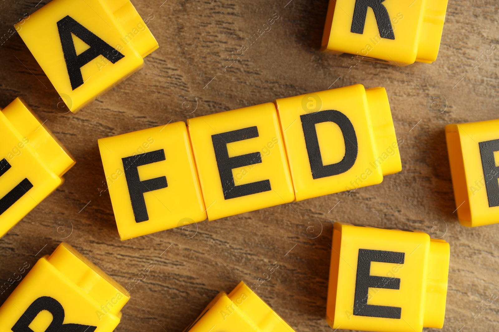 Photo of Cubes with letters Fed (Federal Reserve System) on wooden table, flat lay