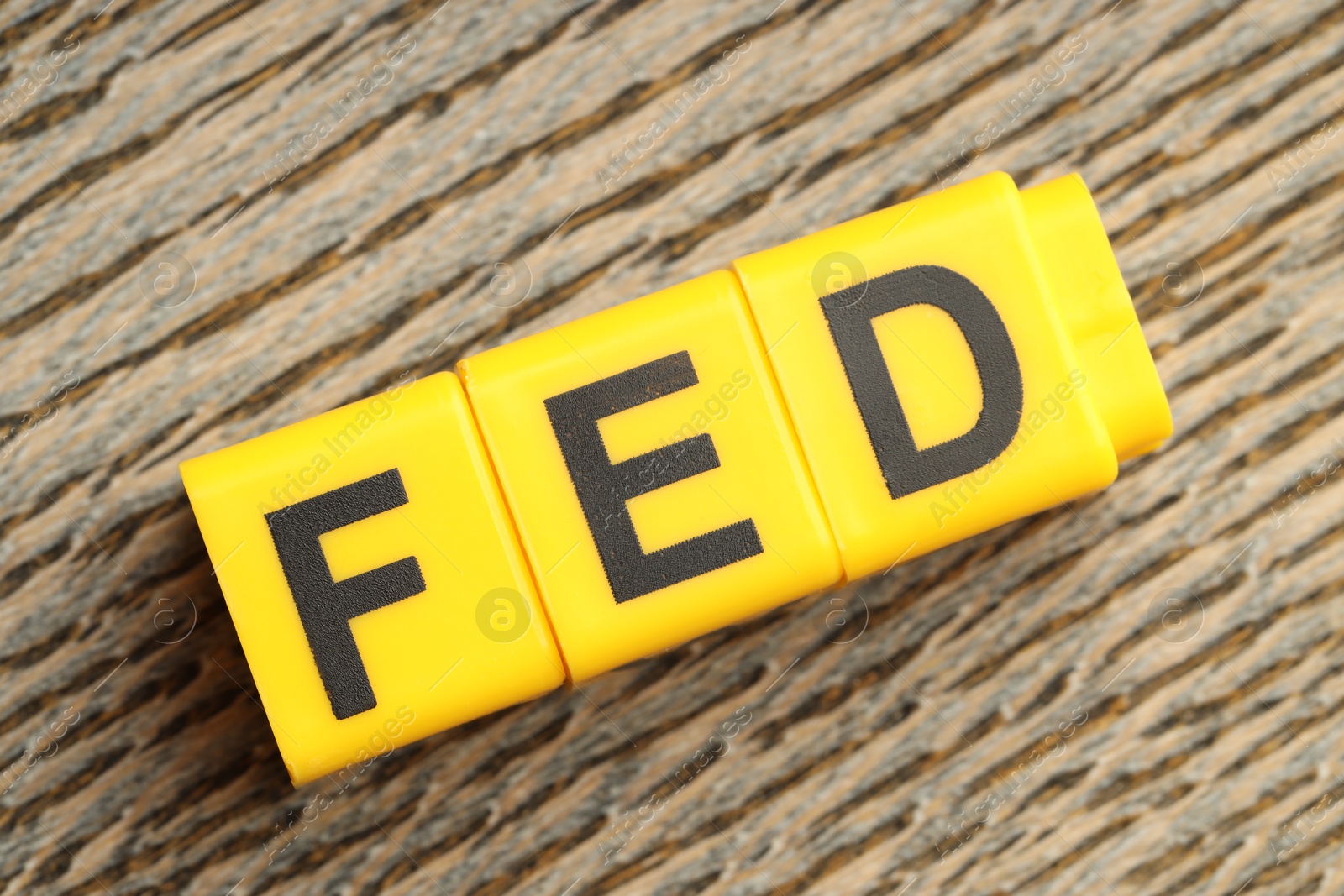 Photo of Cubes with letters Fed (Federal Reserve System) on wooden table, top view