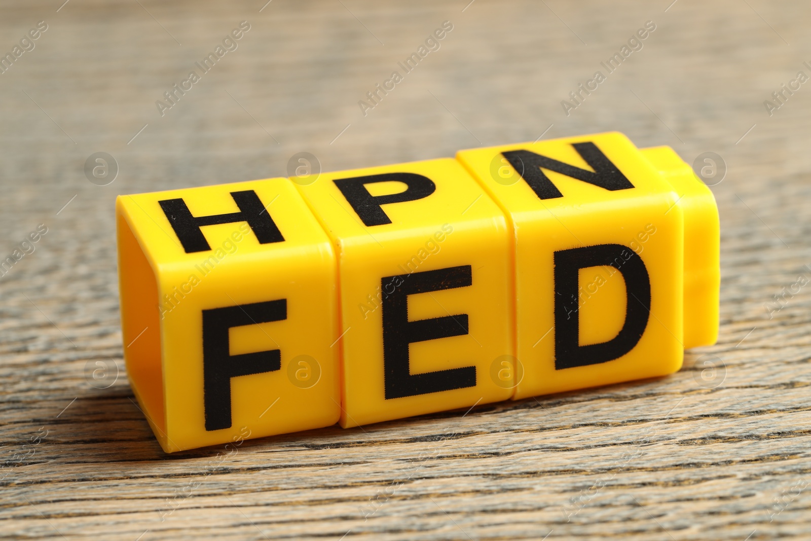 Photo of Cubes with letters Fed (Federal Reserve System) on wooden table, closeup