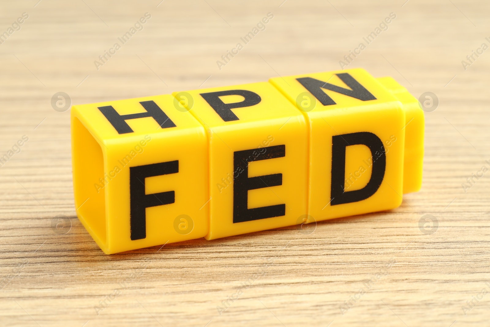 Photo of Cubes with letters Fed (Federal Reserve System) on wooden table, closeup