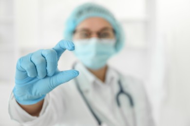 Photo of Doctor holding something in clinic, selective focus. Space for text