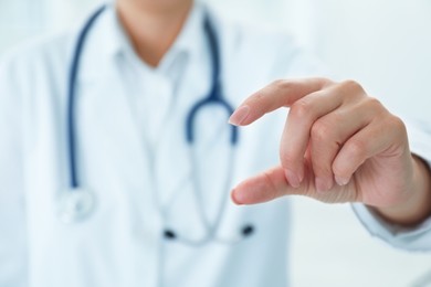 Doctor holding something in clinic, closeup view. Space for text