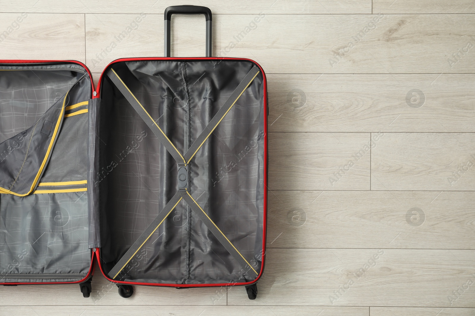 Photo of Open empty suitcase on floor indoors, top view. Space for text