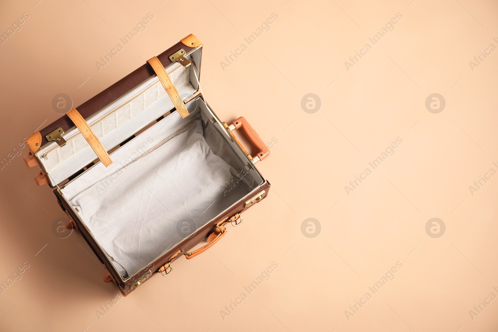 Photo of Open empty suitcase on beige background, top view. Space for text