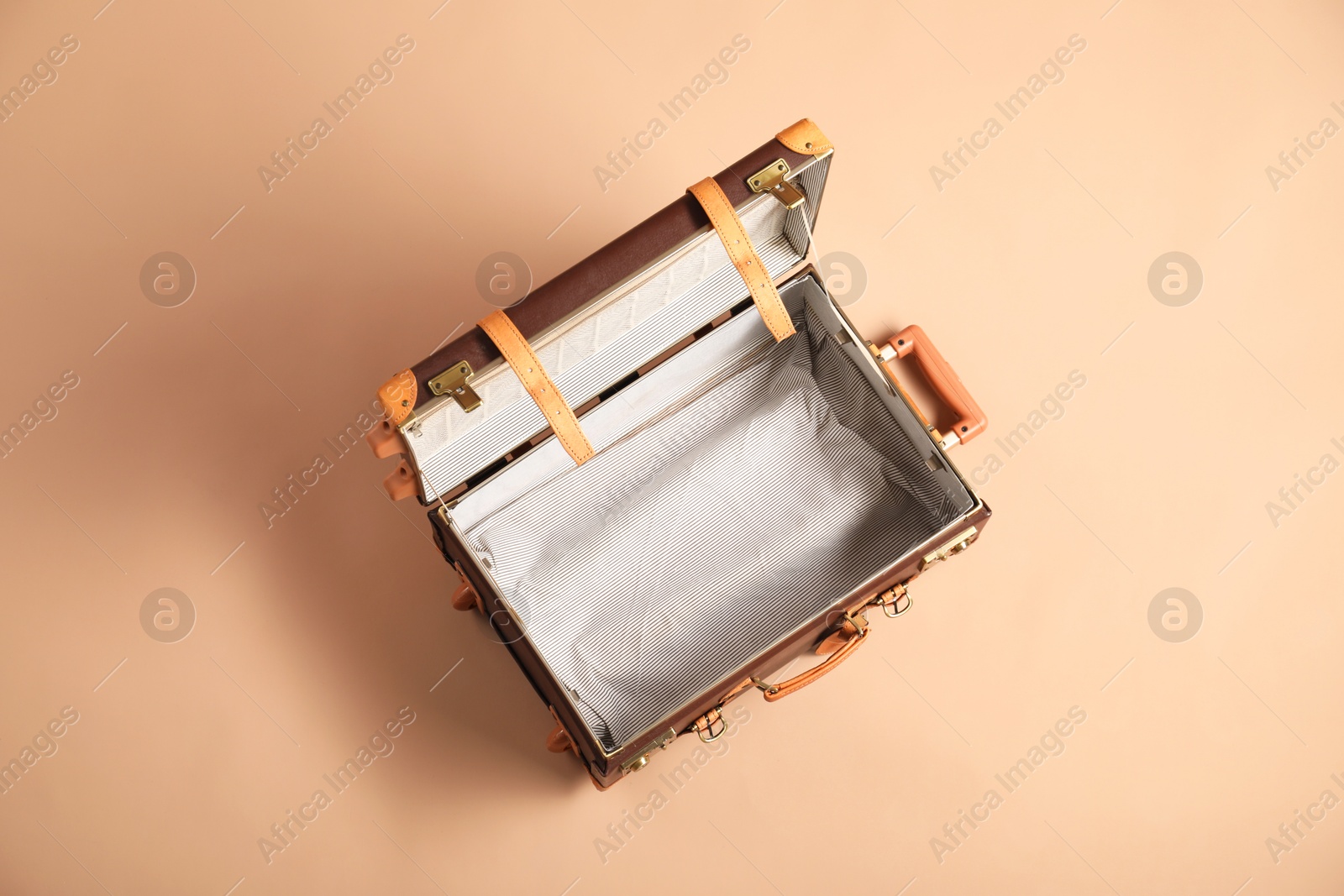 Photo of Open empty suitcase for travelling on beige background, top view