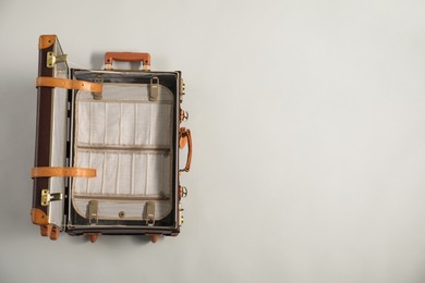 Photo of Open empty suitcase on light grey background, top view. Space for text