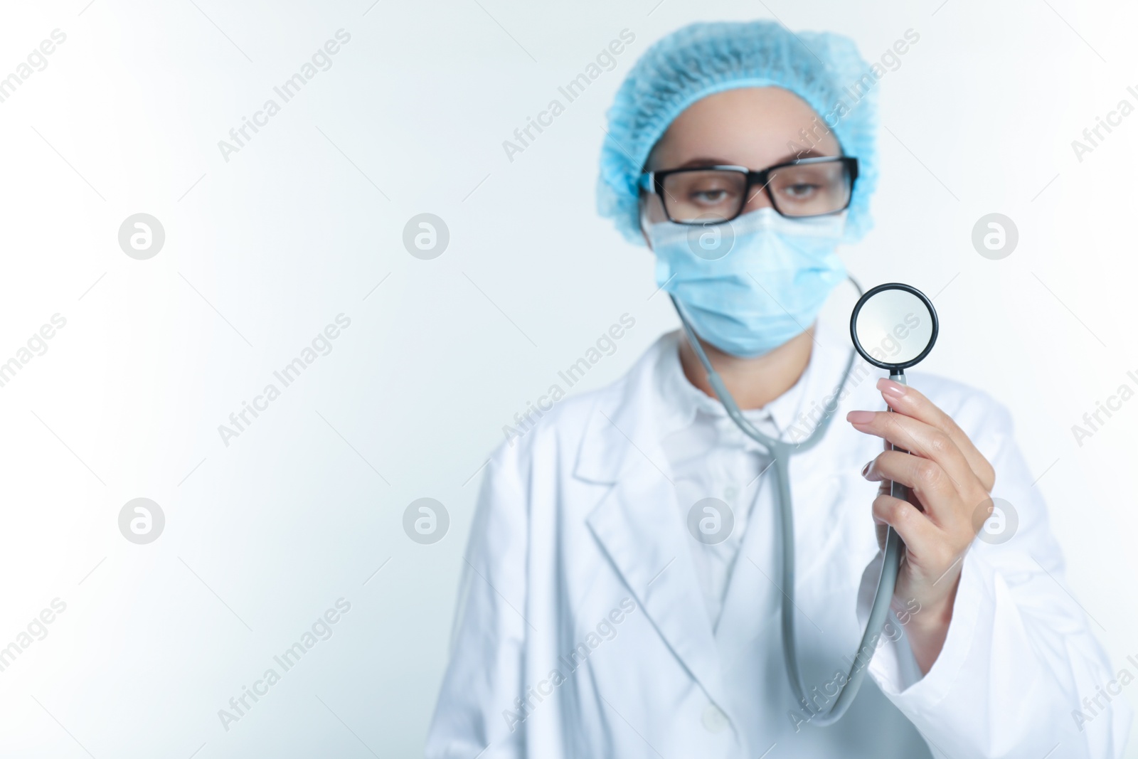 Photo of Doctor holding stethoscope on white background, selective focus. Space for text