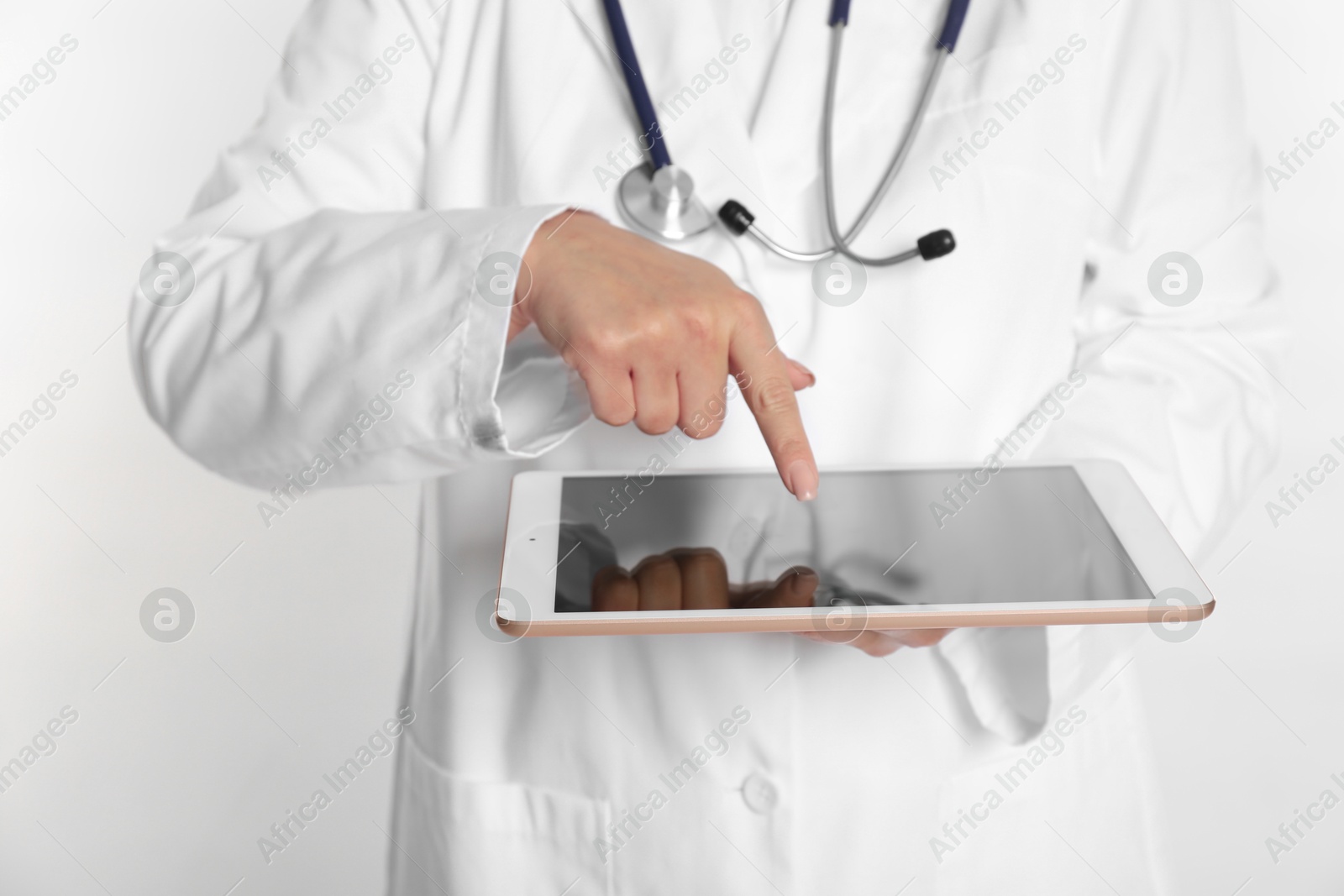 Photo of Doctor using tablet on white background, closeup view