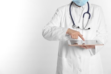 Photo of Doctor using tablet on white background, closeup view. Space for text