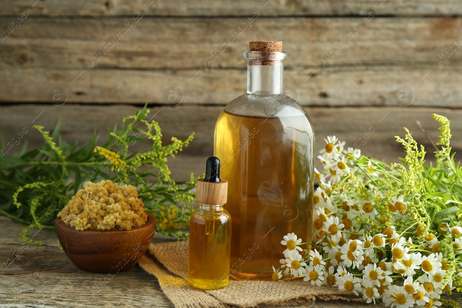 Photo of Tinctures in bottles and medicinal herbs on wooden table