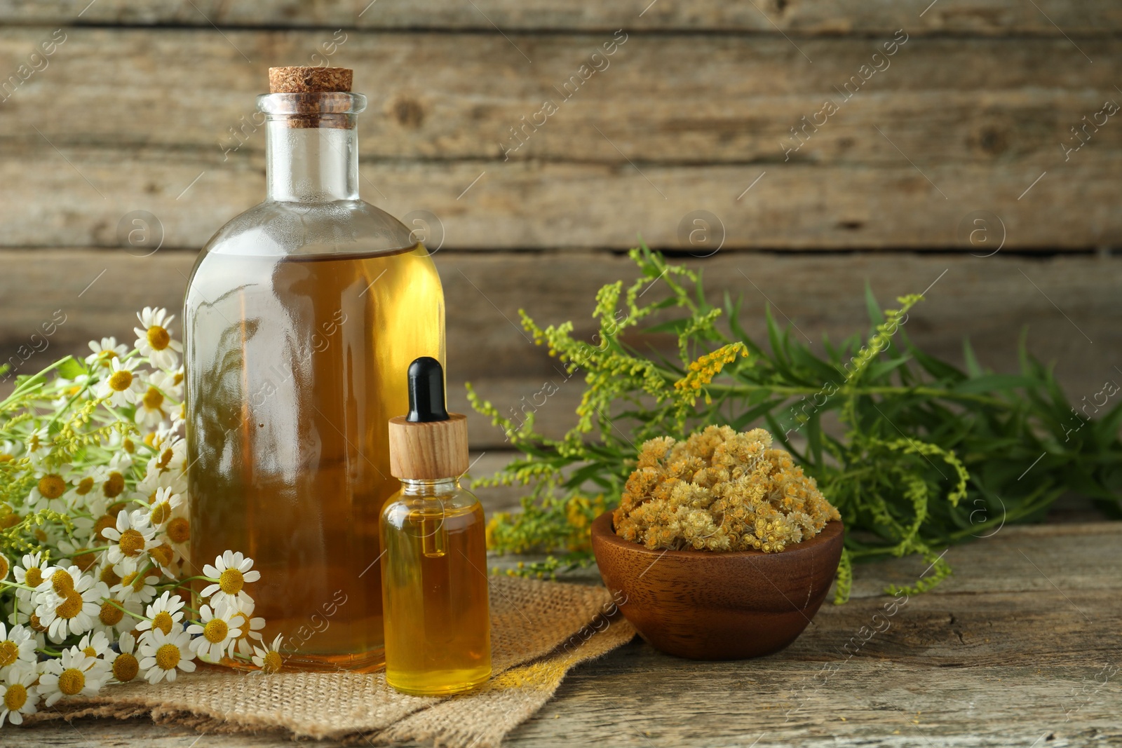 Photo of Tinctures in bottles and medicinal herbs on wooden table