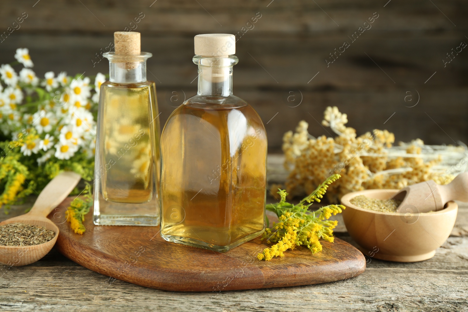 Photo of Tinctures in bottles and medicinal herbs on wooden table