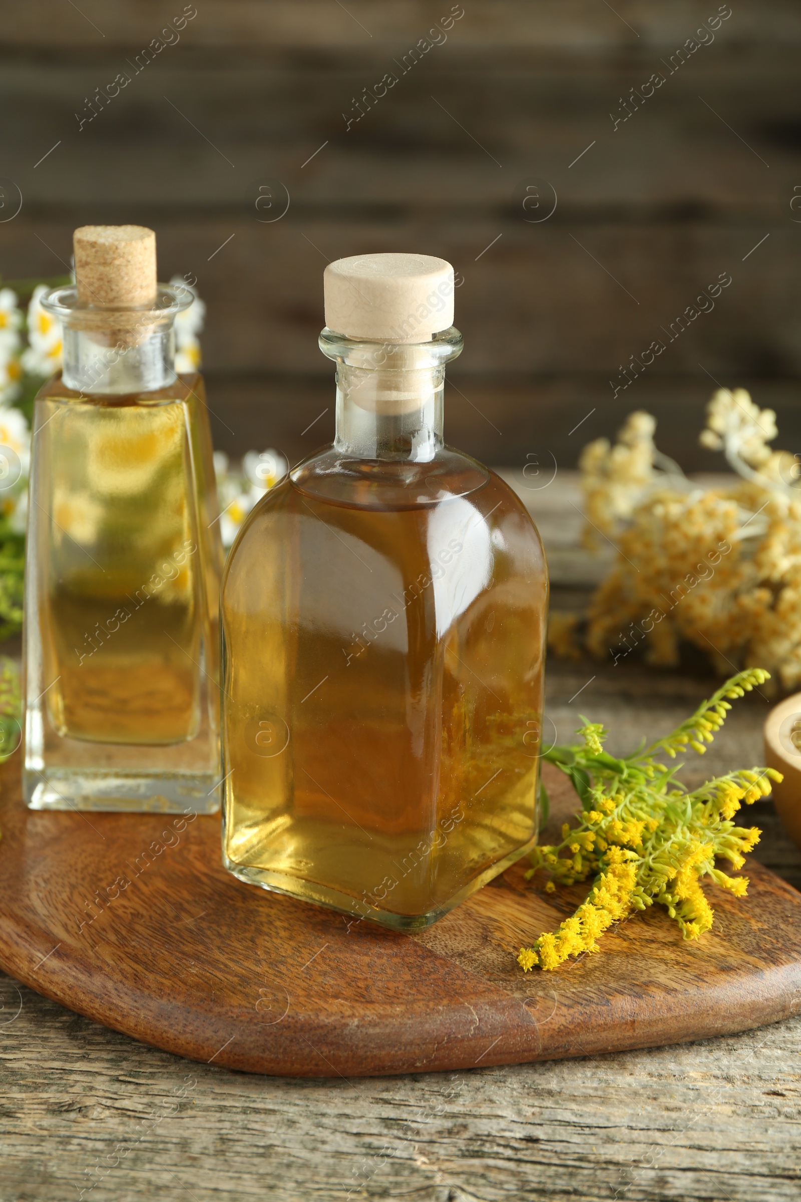 Photo of Tinctures in bottles and medicinal herbs on wooden table