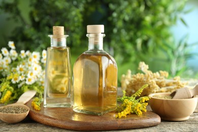 Photo of Tinctures in bottles and medicinal herbs on wooden table