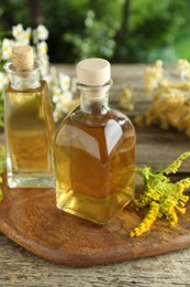 Photo of Tinctures in bottles and medicinal herbs on wooden table