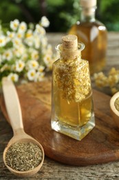 Photo of Tincture in bottle and medicinal herbs on wooden table, closeup