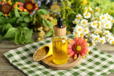 Photo of Tincture in bottle and medicinal herbs on wooden table