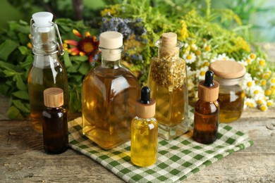 Photo of Different tinctures in bottles and medicinal herbs on wooden table