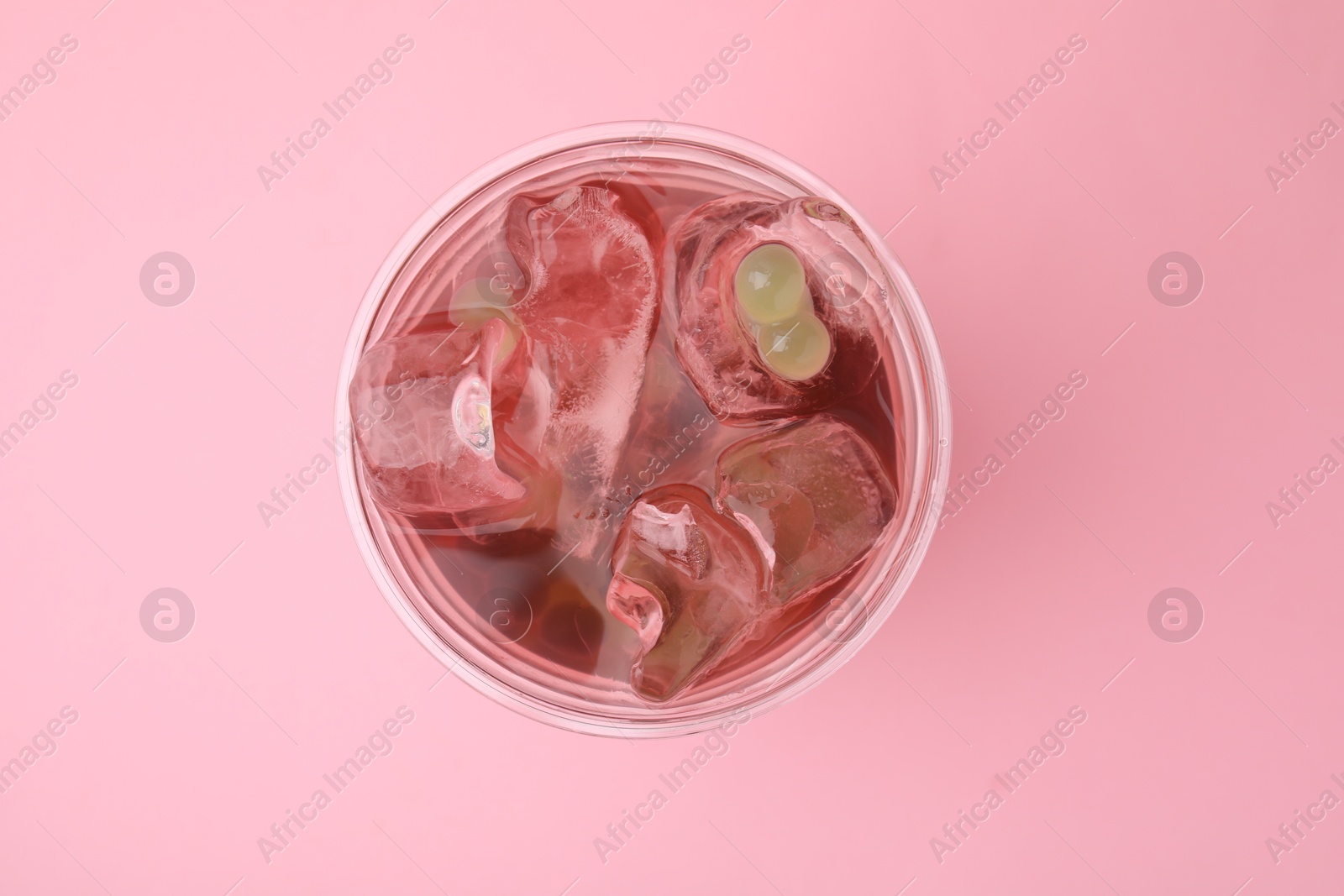 Photo of Tasty bubble tea in plastic cup on pink background, top view