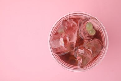 Tasty bubble tea in plastic cup on pink background, top view. Space for text