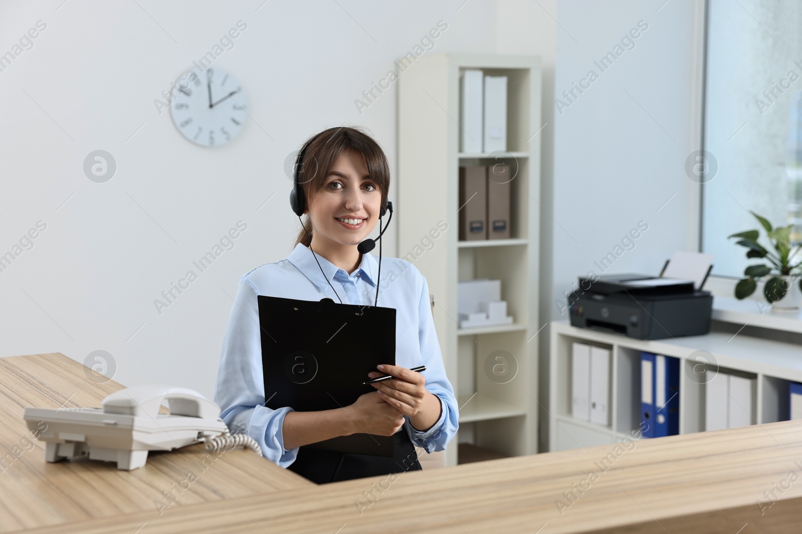 Photo of Professional receptionist working at wooden desk in office