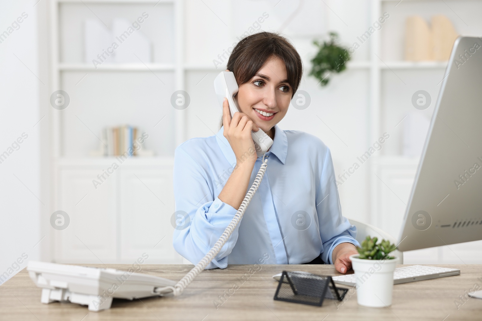 Photo of Portrait of receptionist at wooden desk in office