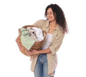 Happy woman with basket full of laundry on white background