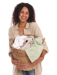 Happy woman with basket full of laundry on white background