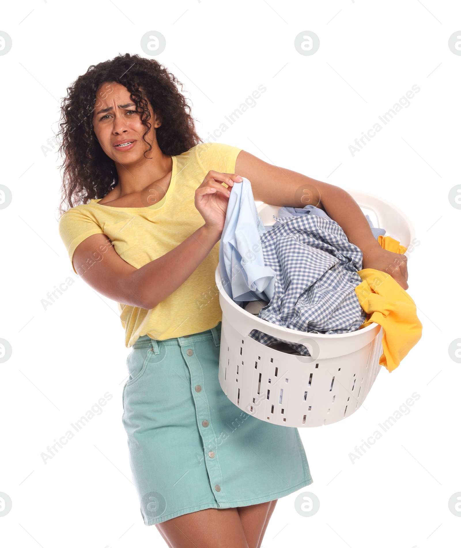 Photo of Displeased woman with basket full of laundry on white background