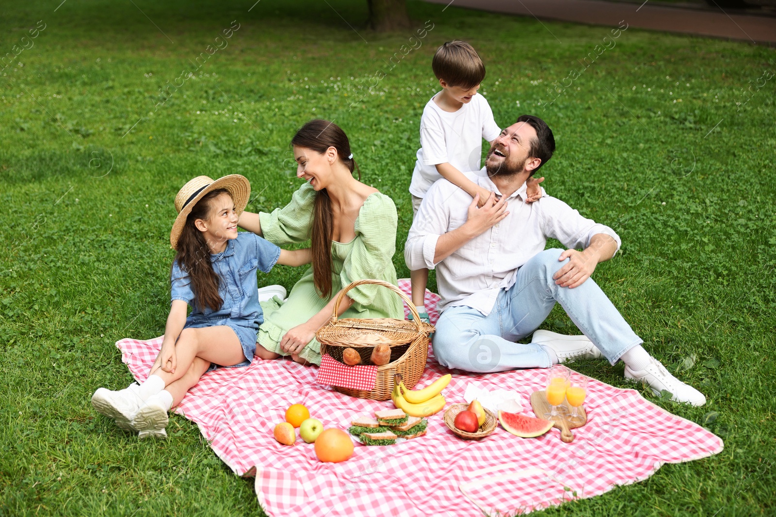 Photo of Happy family having picnic together in park