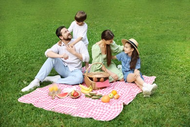 Happy family having picnic together in park