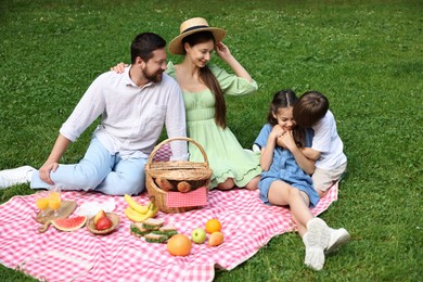 Happy family having picnic together in park