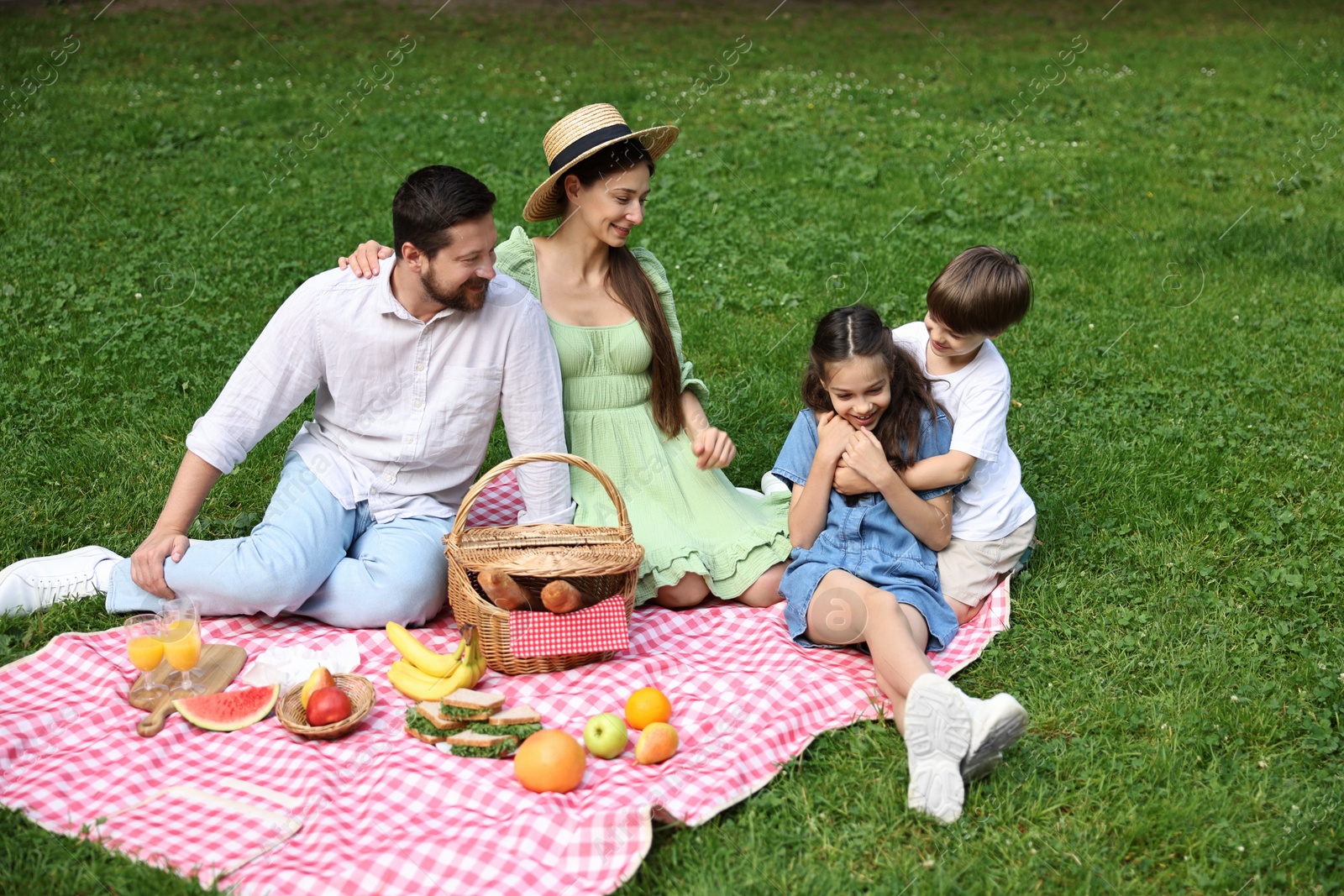 Photo of Happy family having picnic together in park