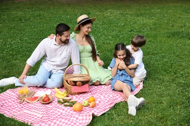 Photo of Happy family having picnic together in park