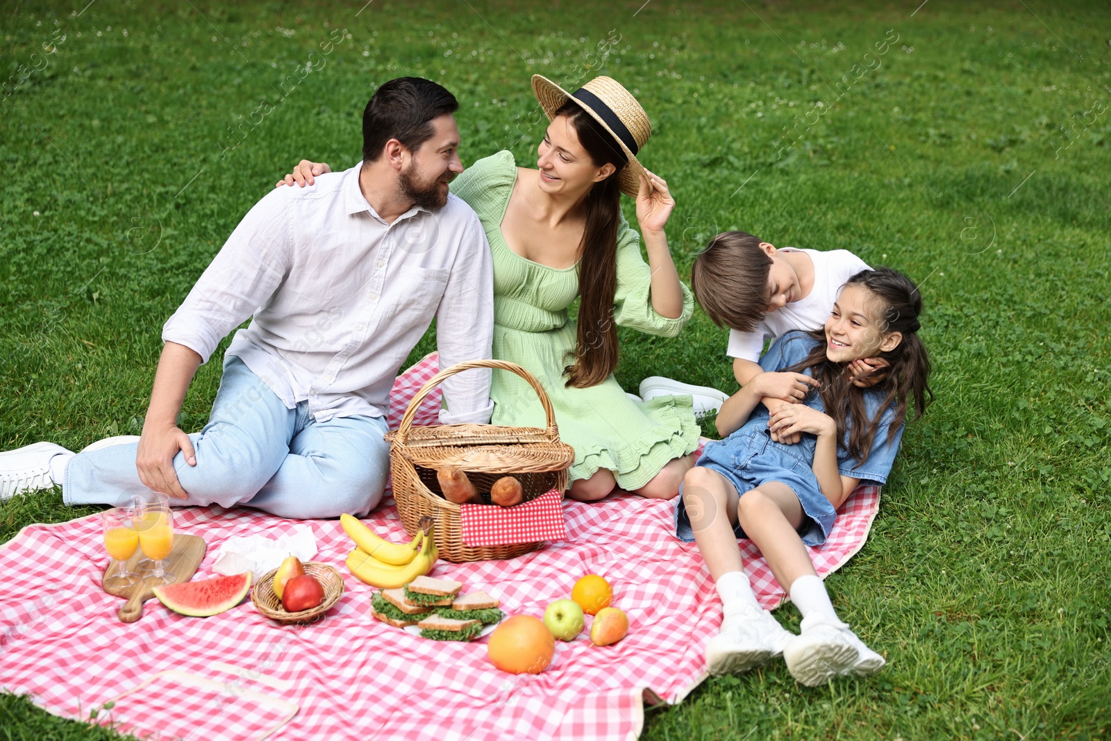 Photo of Happy family having picnic together in park