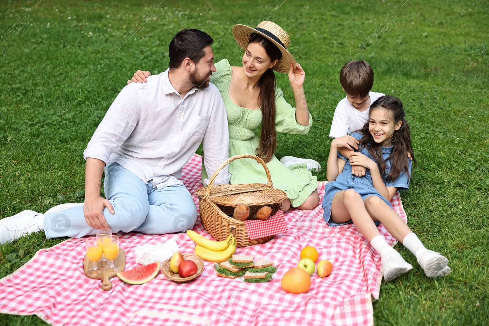 Photo of Happy family having picnic together in park