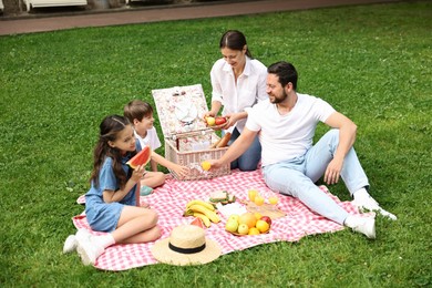 Happy family having picnic together in park