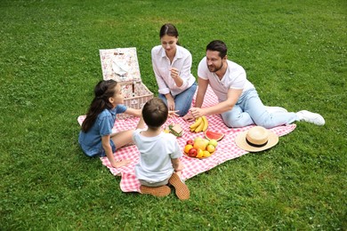 Photo of Family playing rock, paper and scissors during picnic outdoors