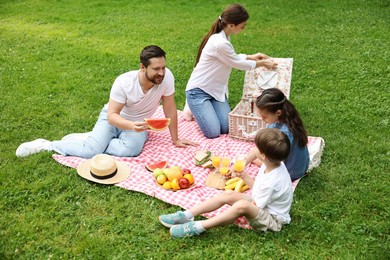 Photo of Happy family having picnic together in park