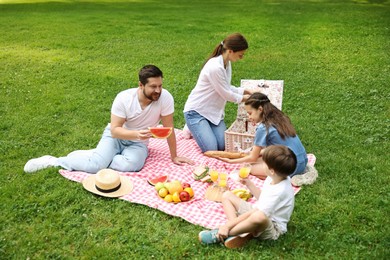 Photo of Lovely family having picnic together in park