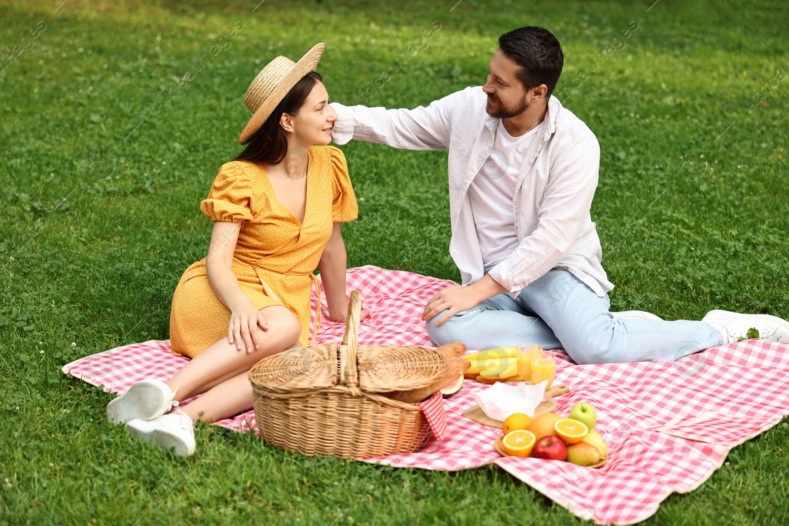 Photo of Lovely couple spending time together on picnic blanket outdoors