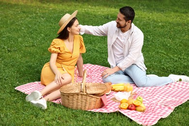 Lovely couple spending time together on picnic blanket outdoors