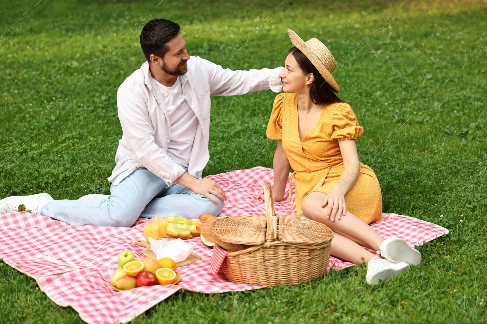 Photo of Lovely couple spending time together on picnic blanket outdoors