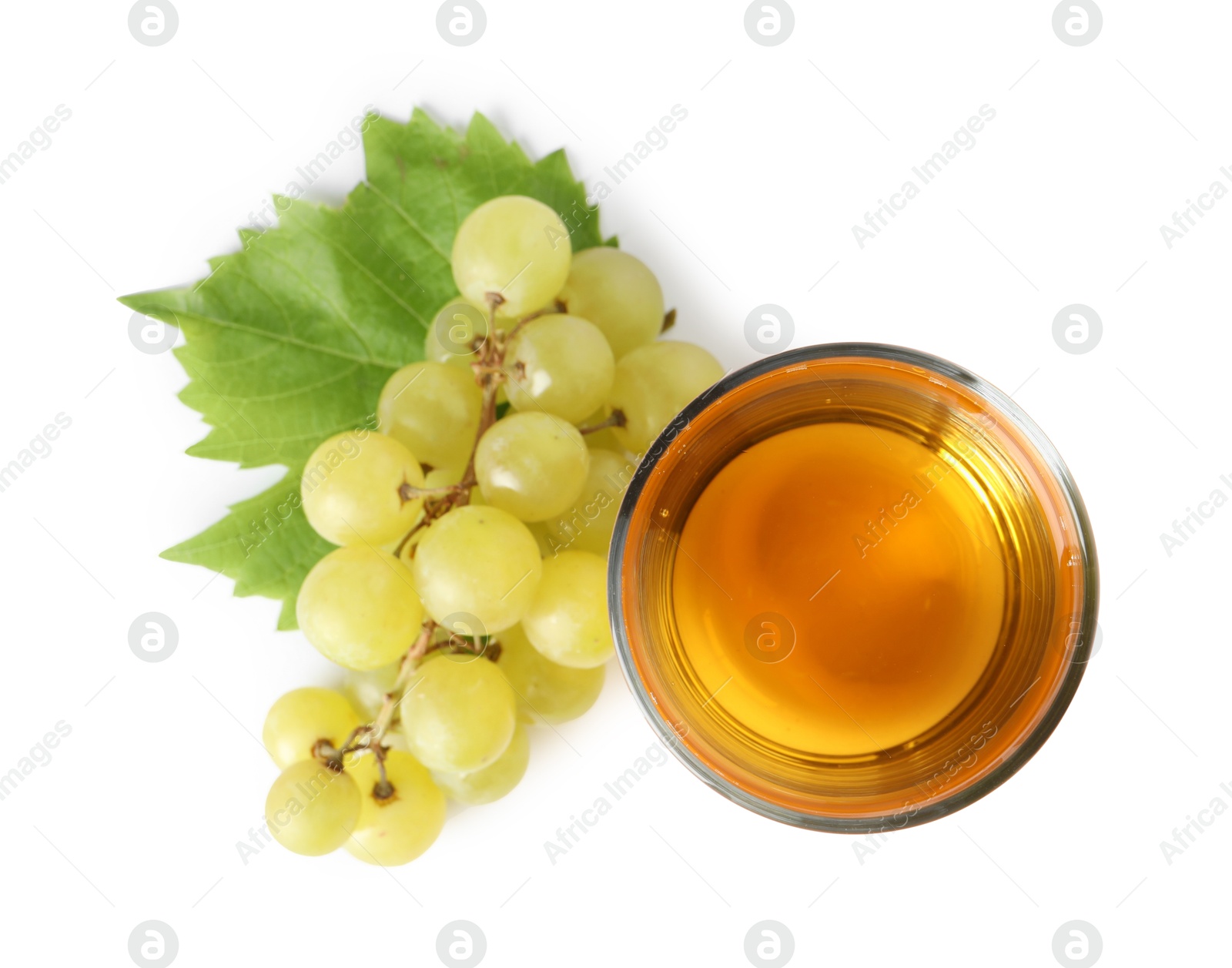 Photo of Tasty juice in glass, fresh grapes and leaf isolated on white, top view