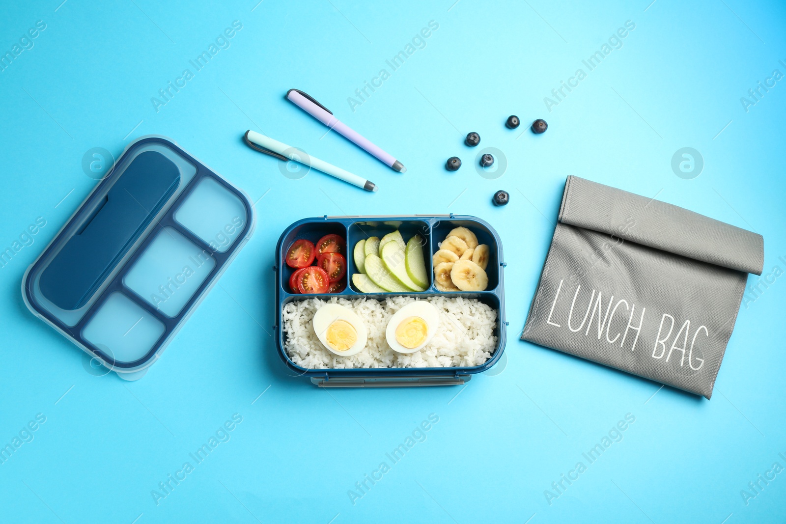 Photo of Bag, lunch box with snacks and pens on light blue background, flat lay