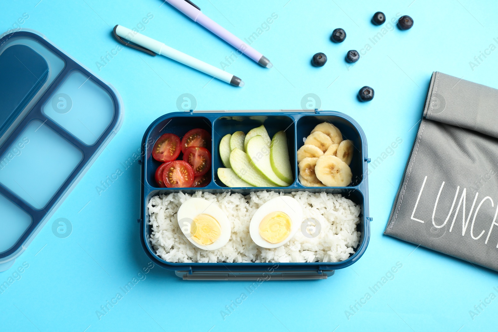 Photo of Bag, lunch box with snacks and pens on light blue background, flat lay