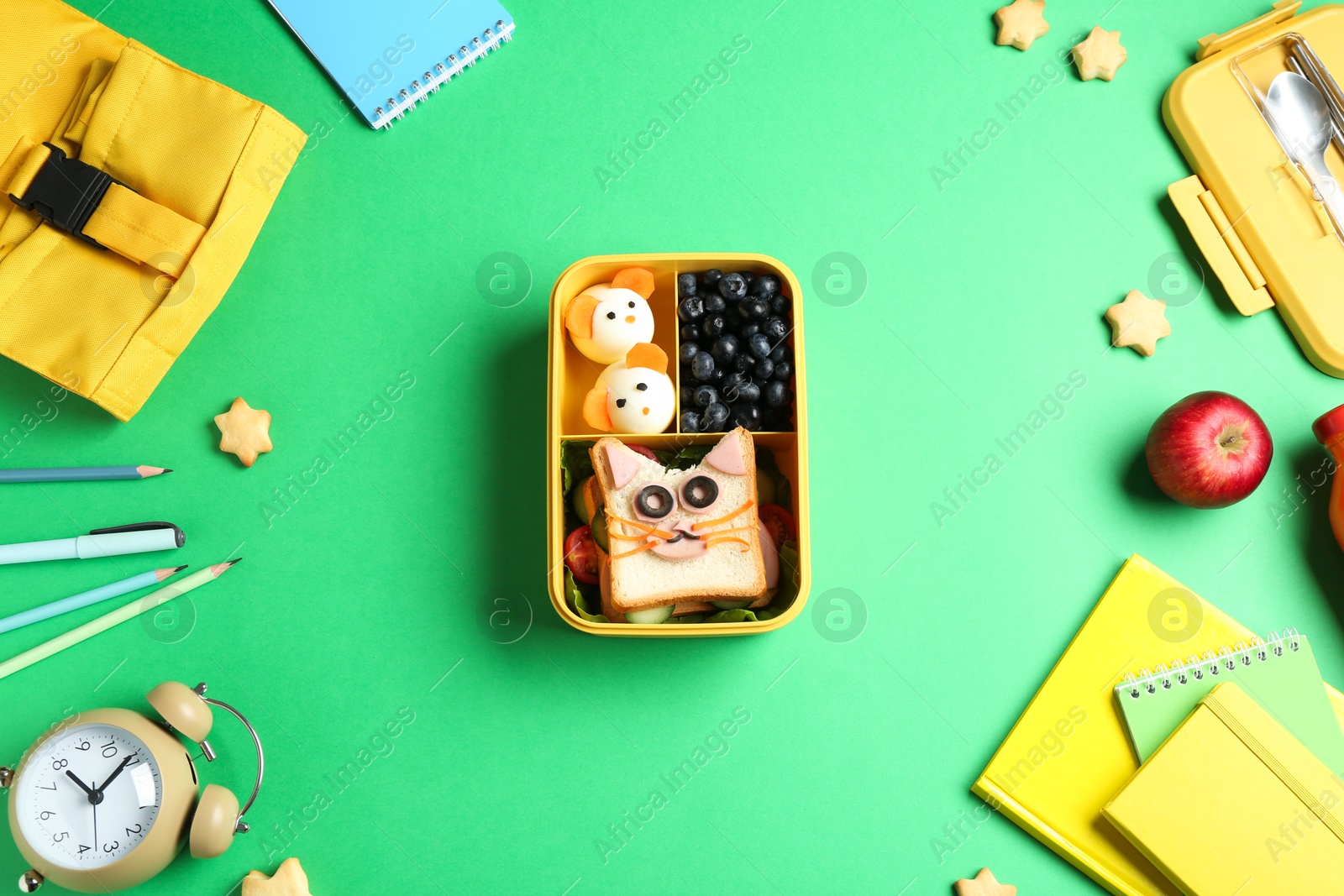 Photo of Flat lay composition with lunch box and snacks on green table